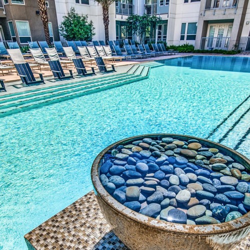 Resort-style swimming pool a pool with chairs around it